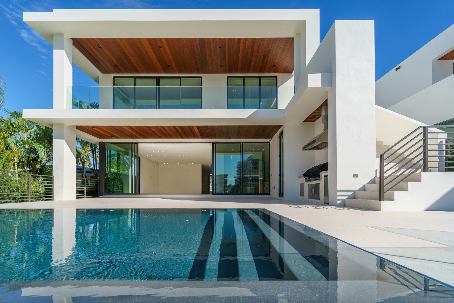 villa moderne avec piscine et palmiers, exemple de bien résidentiel suivi par une agence de la vente à la gestion