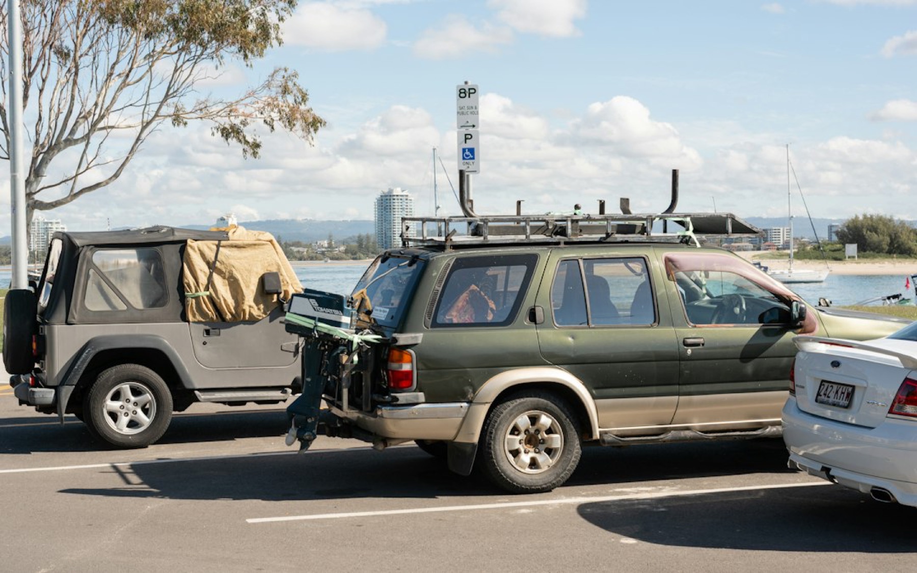 Véhicule qui tracte une petite remorque à bateau sur un parking, avant embarquement