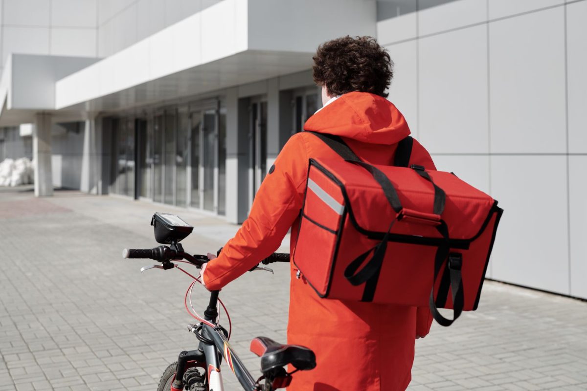 livreur a velo avec sac a dos isotherme rouge