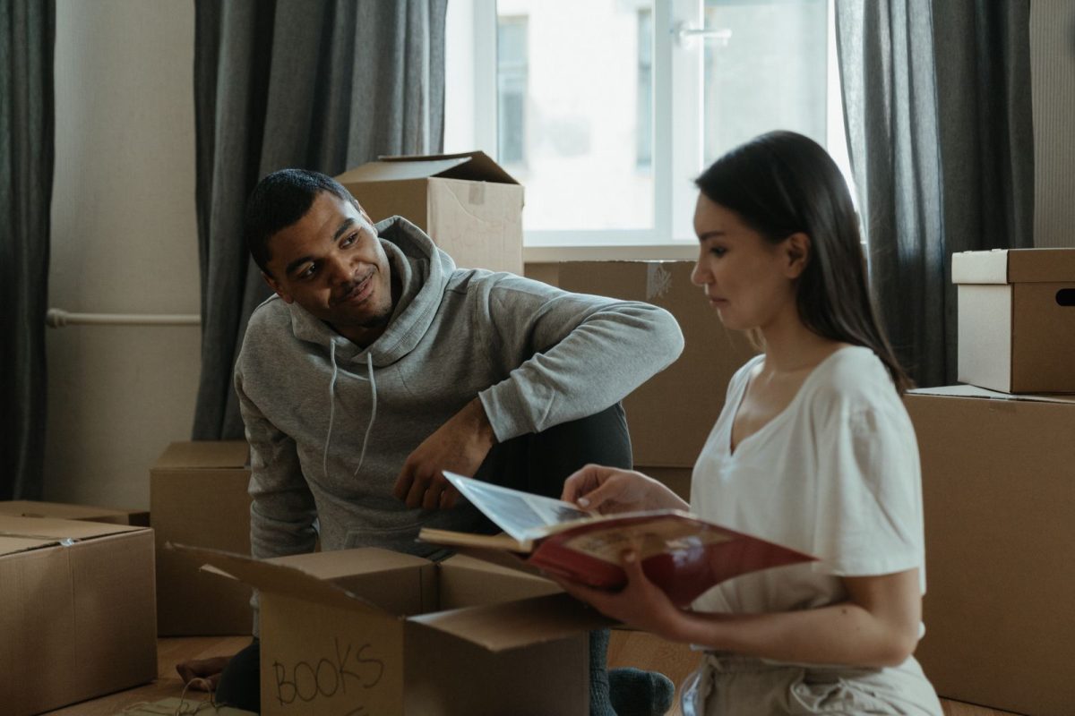 Couple assis au sol entoure de cartons pendant un demenagement
