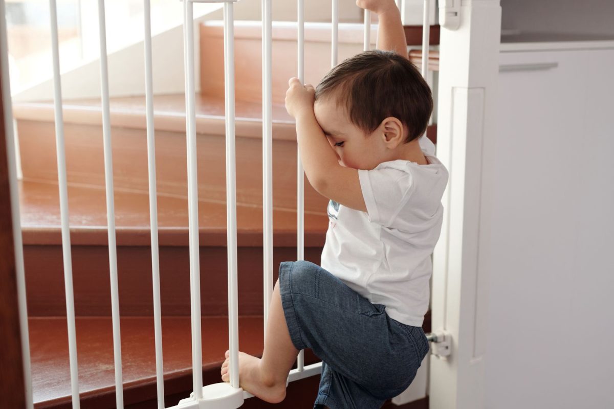 Enfant grimpant sur une barriere de securite