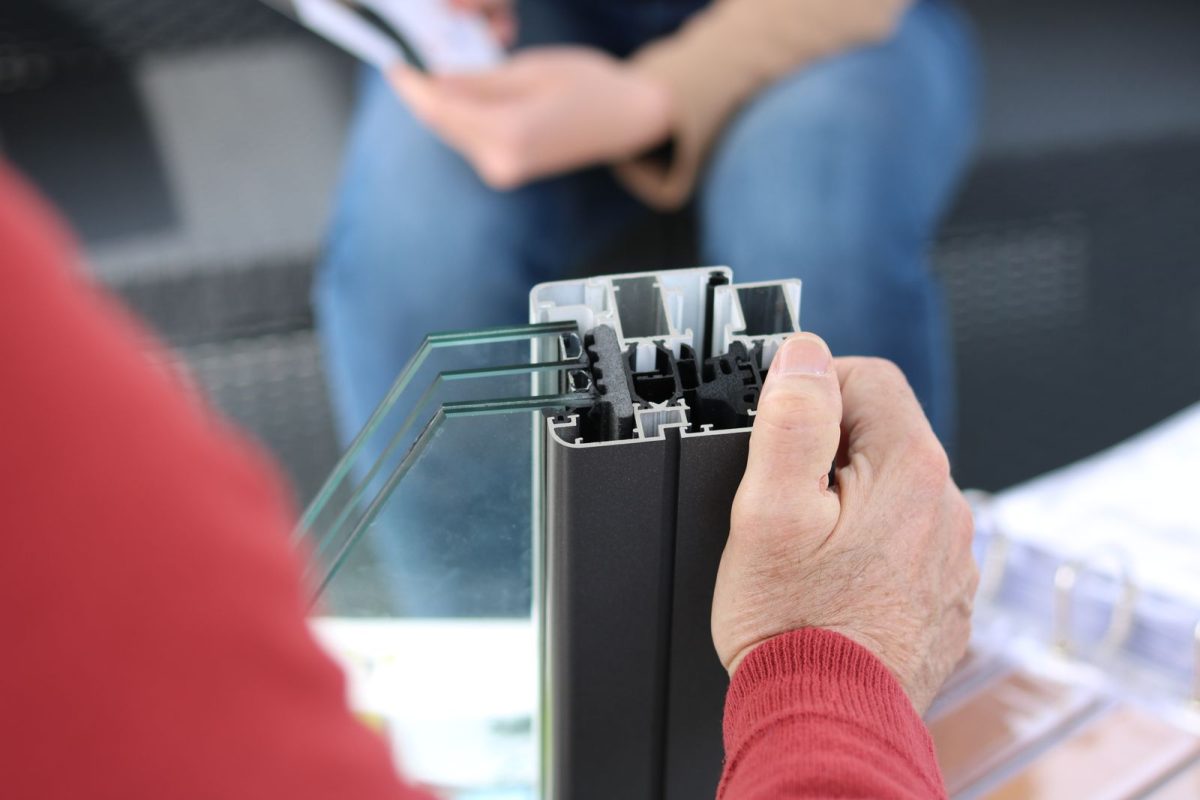 Une main montre le joint sur un cadre de fenetre en aluminium.