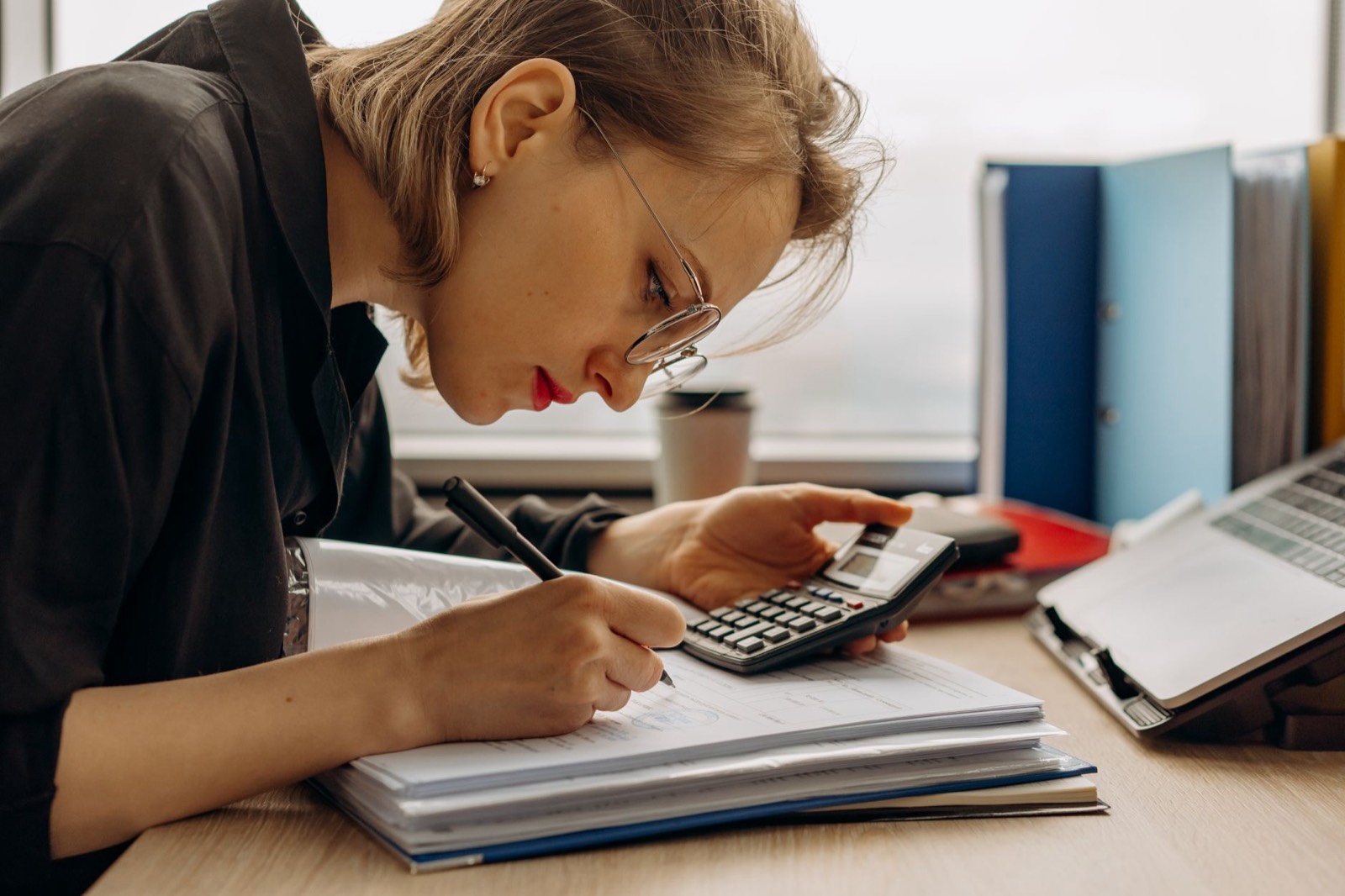 classeur de comptabilité et calculatrice sur un bureau pour la gestion de la copropriété