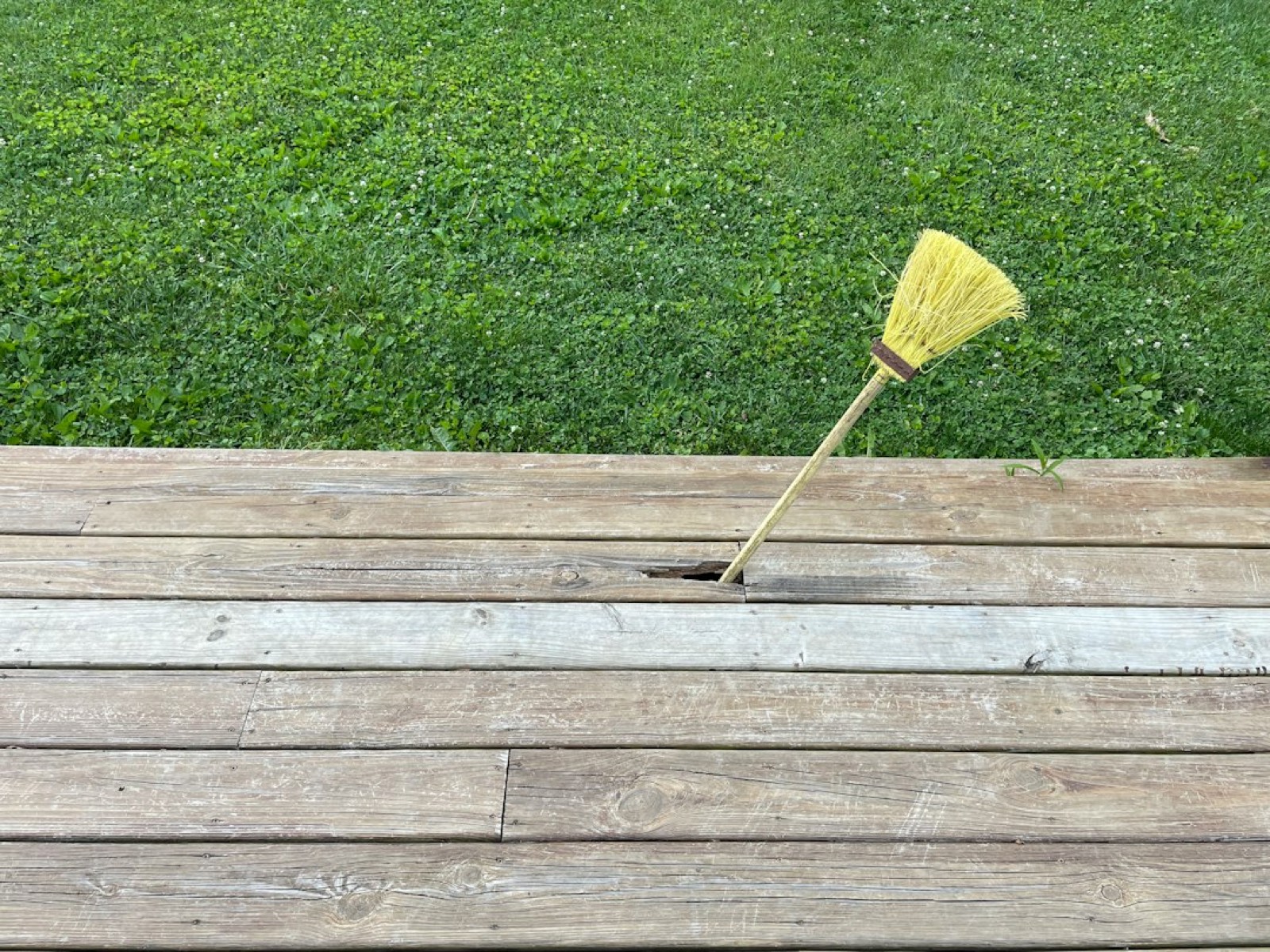 Brosse de nettoyage sur une terrasse en bois extérieure