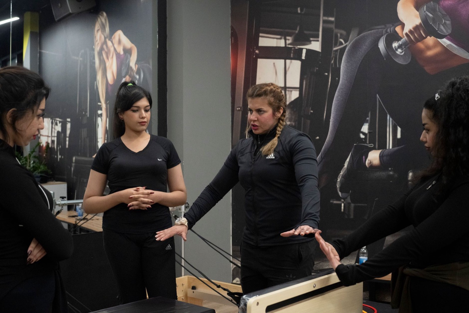 Une coach explique un exercice à un petit groupe dans une salle de sport