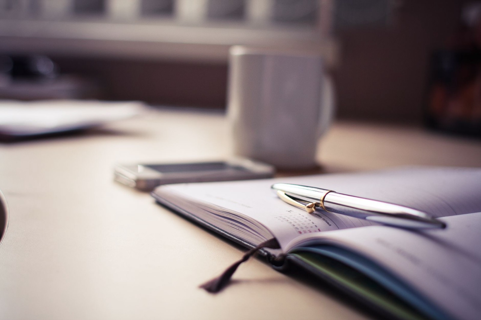 Carnet de planning et café sur un bureau pour organiser une activité de services à domicile